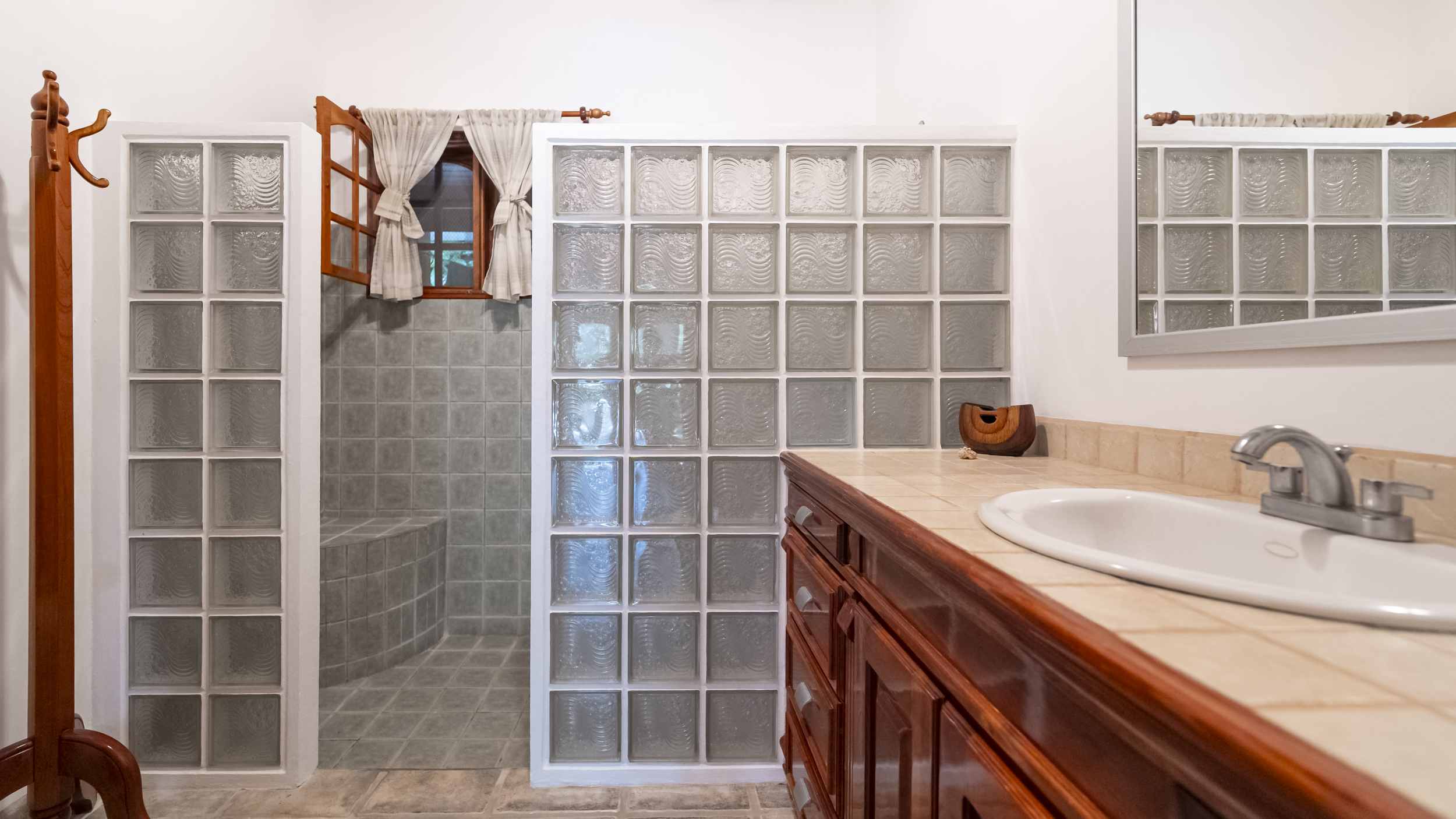 baño con ducha de bloques de vidrio en Hummingbird House Samara Costa Rica