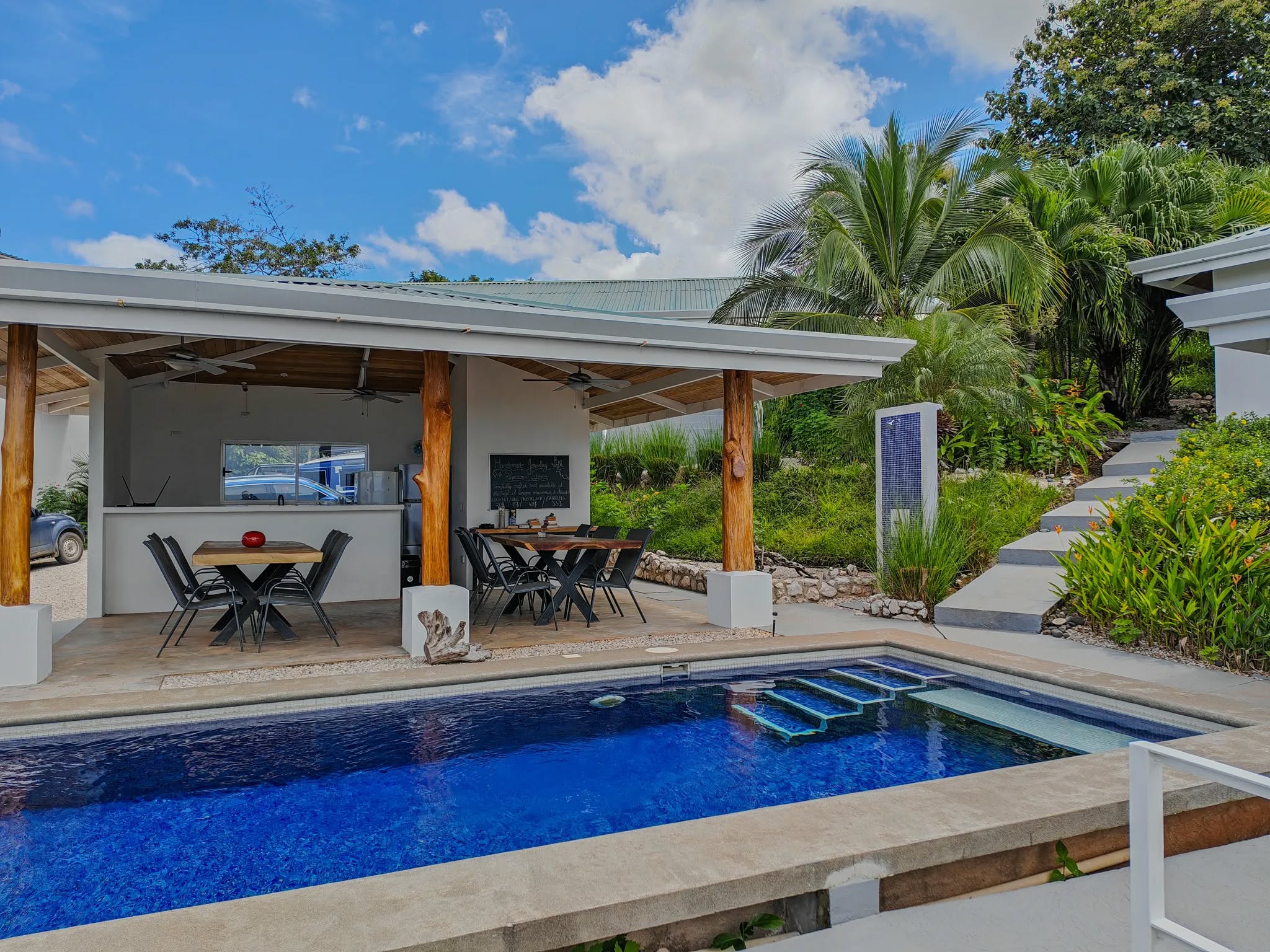 piscina con zona lounge y entorno tropical refugio infinito